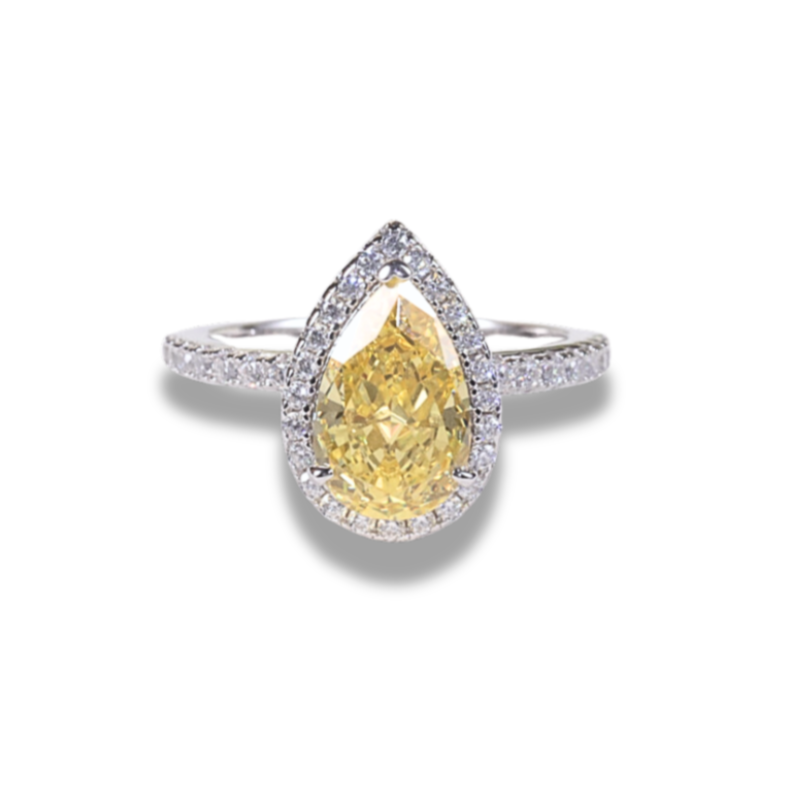 A pear cut yellow cubic zirconia ring with a halo effect, set in a white gold band.