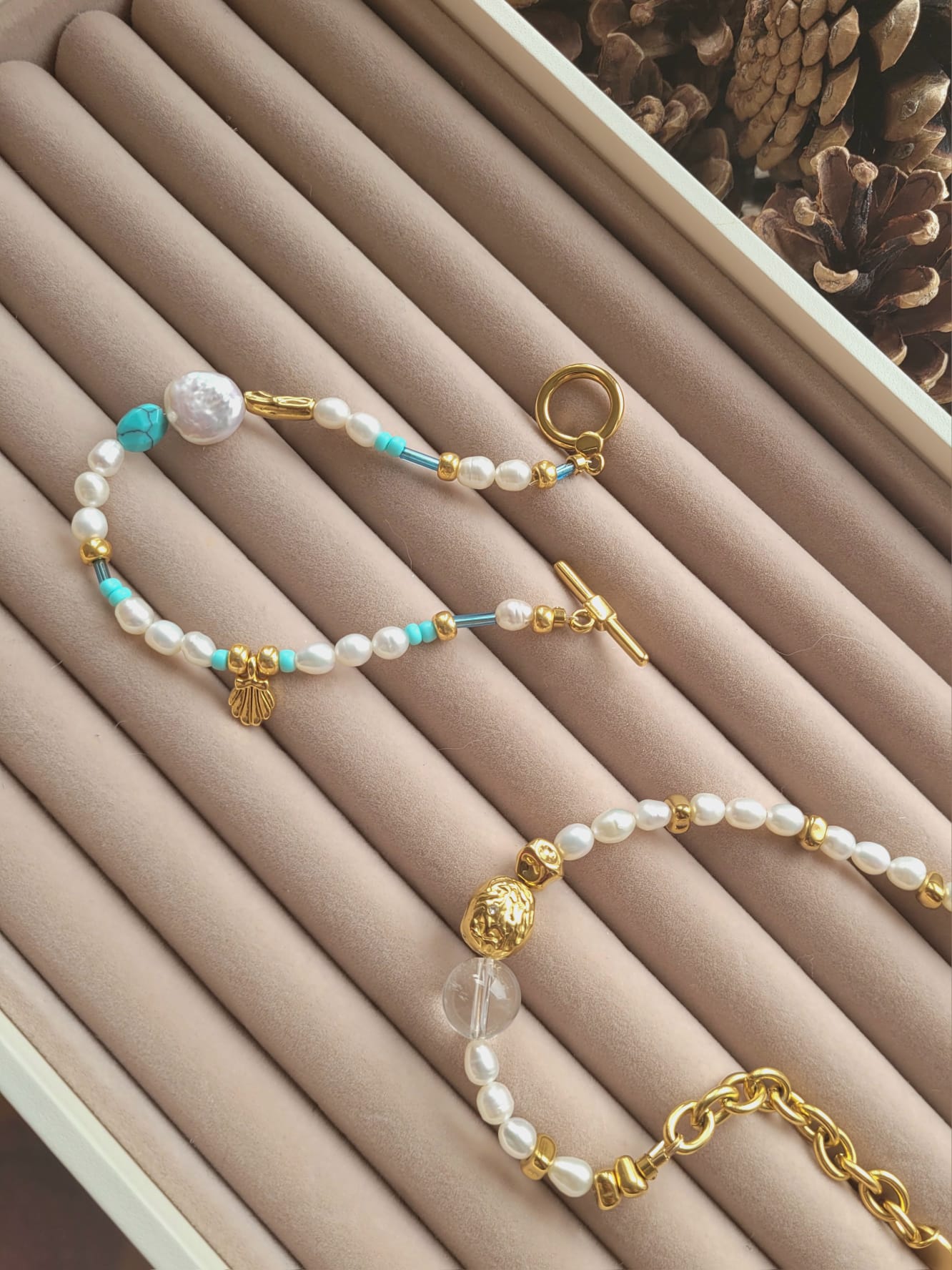 Pearl and gold bracelet on a pink jewelry display box